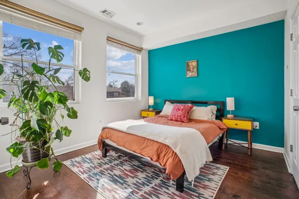 a bedroom with a bed and a potted plant