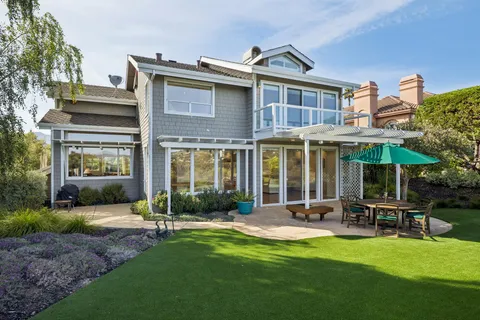 a view of a house with a yard and sitting area