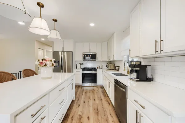 a kitchen with refrigerator a stove a sink and cabinets