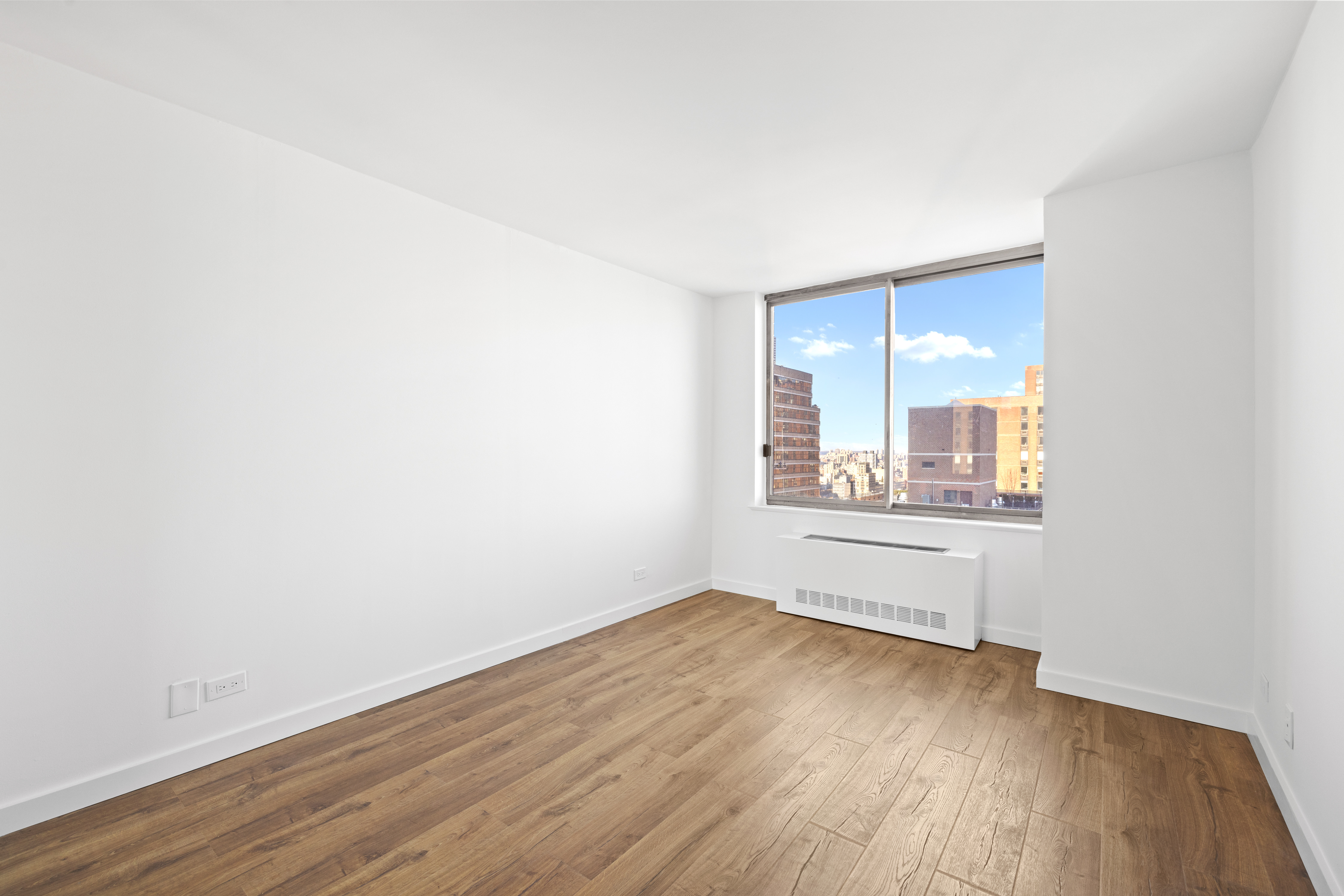 200 East 89th Street, Unit 29D Manhattan, NY 10128 - Photo 4 of 16 an empty room with wooden floor and windows
