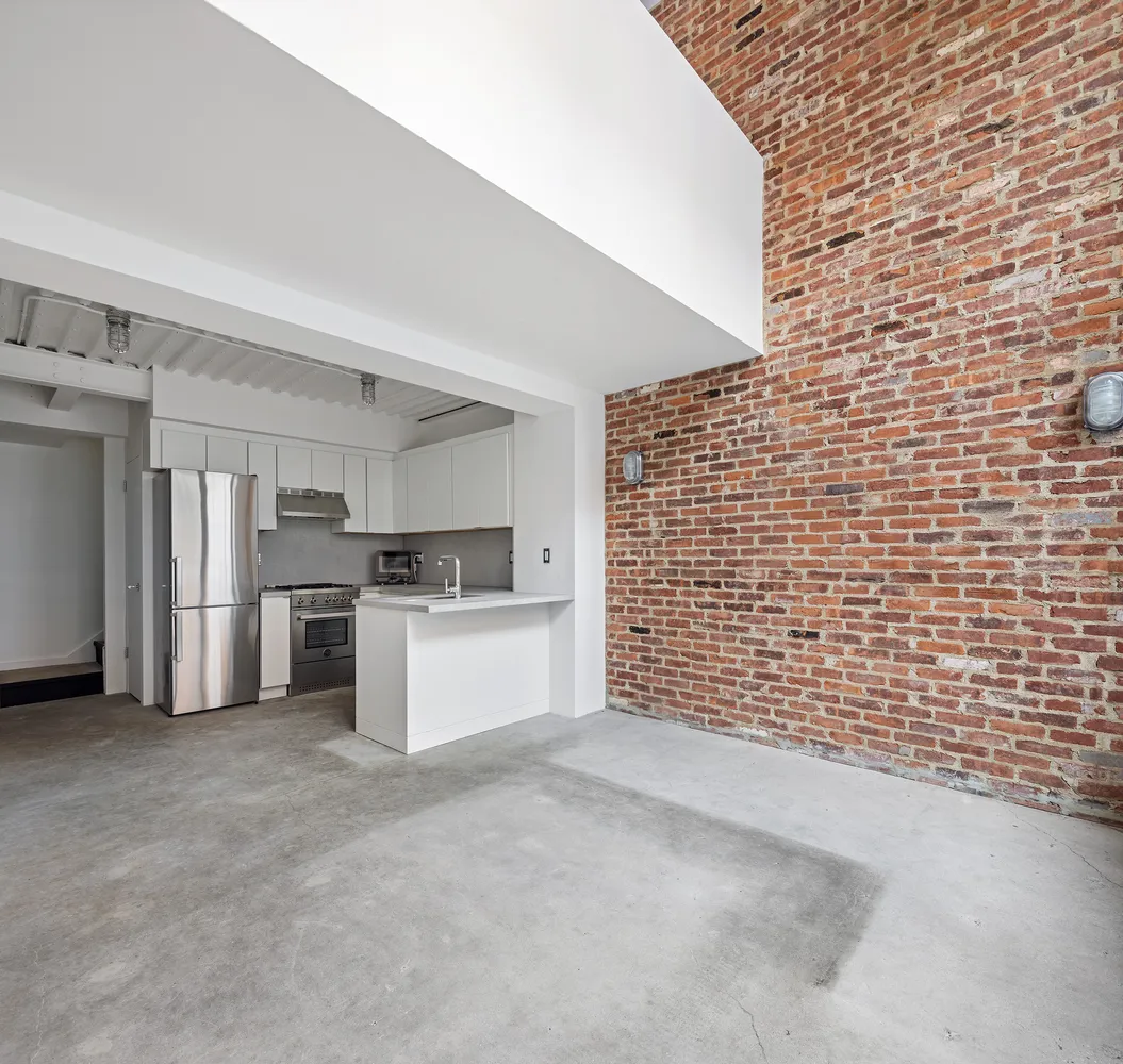 a view of a kitchen with refrigerator and white cabinets