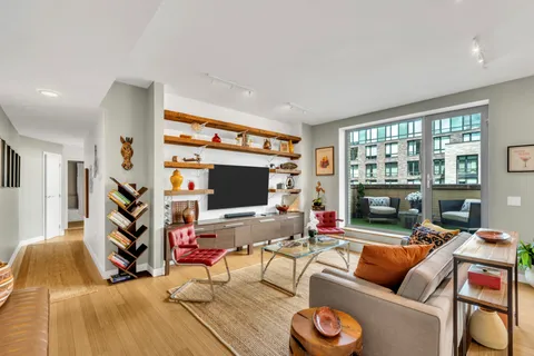 a living room with furniture and a flat screen tv with wooden floor