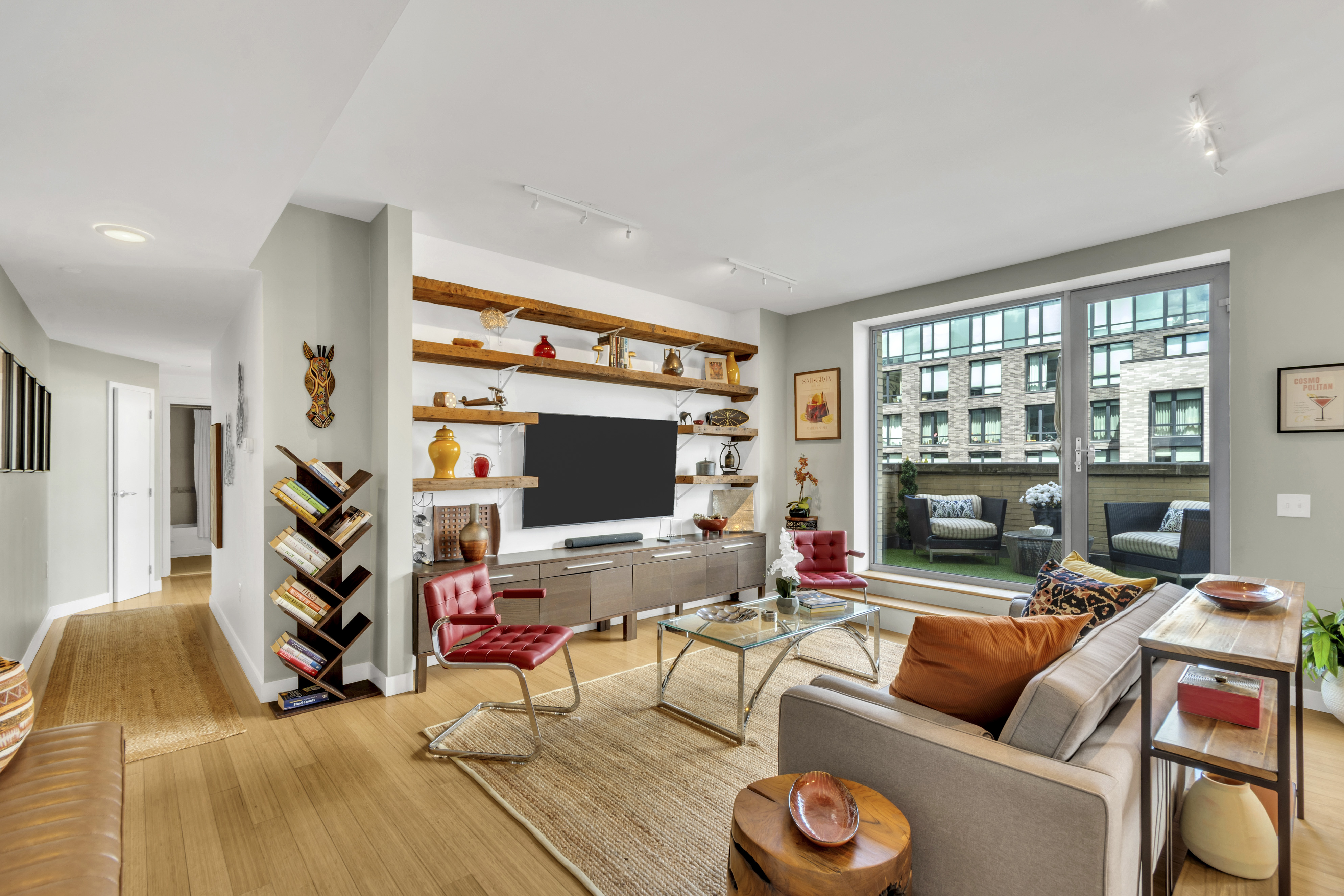 40 West 116th Street, Unit A907 Manhattan, NY 10026 - Photo 2 of 34 a living room with furniture and a flat screen tv with wooden floor