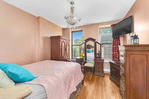 a bedroom with a large bed and a chandelier