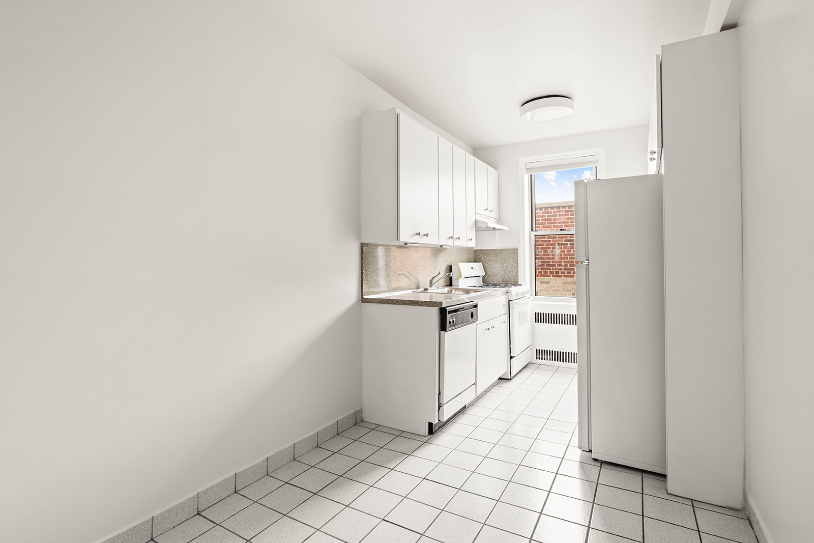 76-12 35th Avenue, Unit 6J Queens, NY 11372 - Photo 11 of 17 a kitchen with white cabinets and white appliances