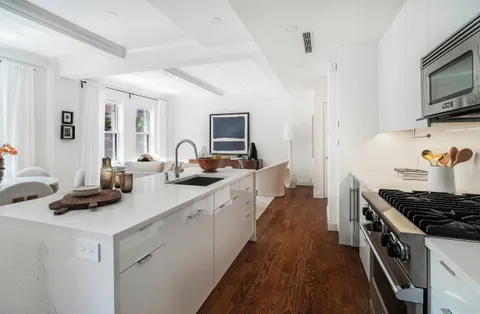 a kitchen with sink a stove and cabinets