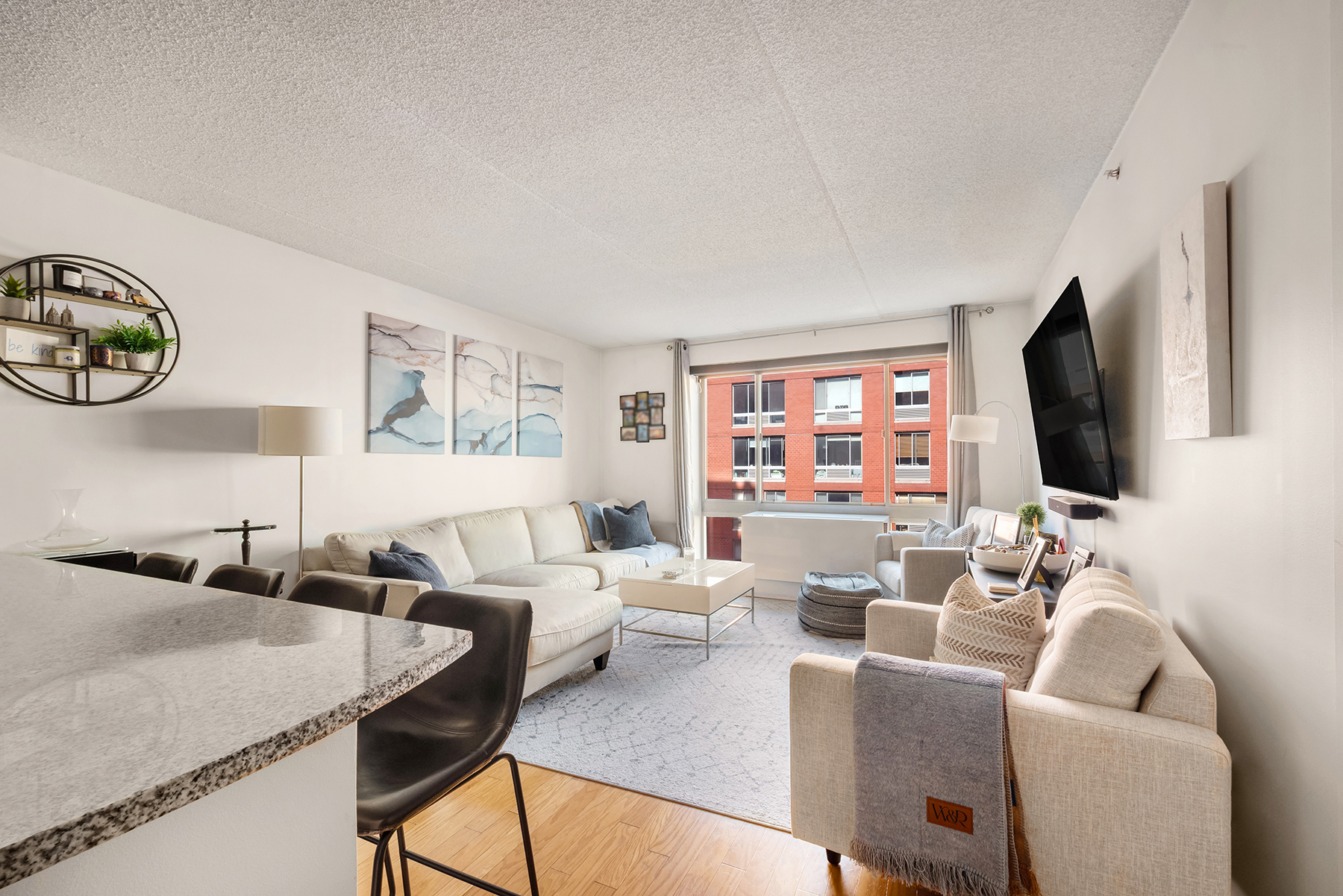 a living room with furniture a flat screen tv and a window