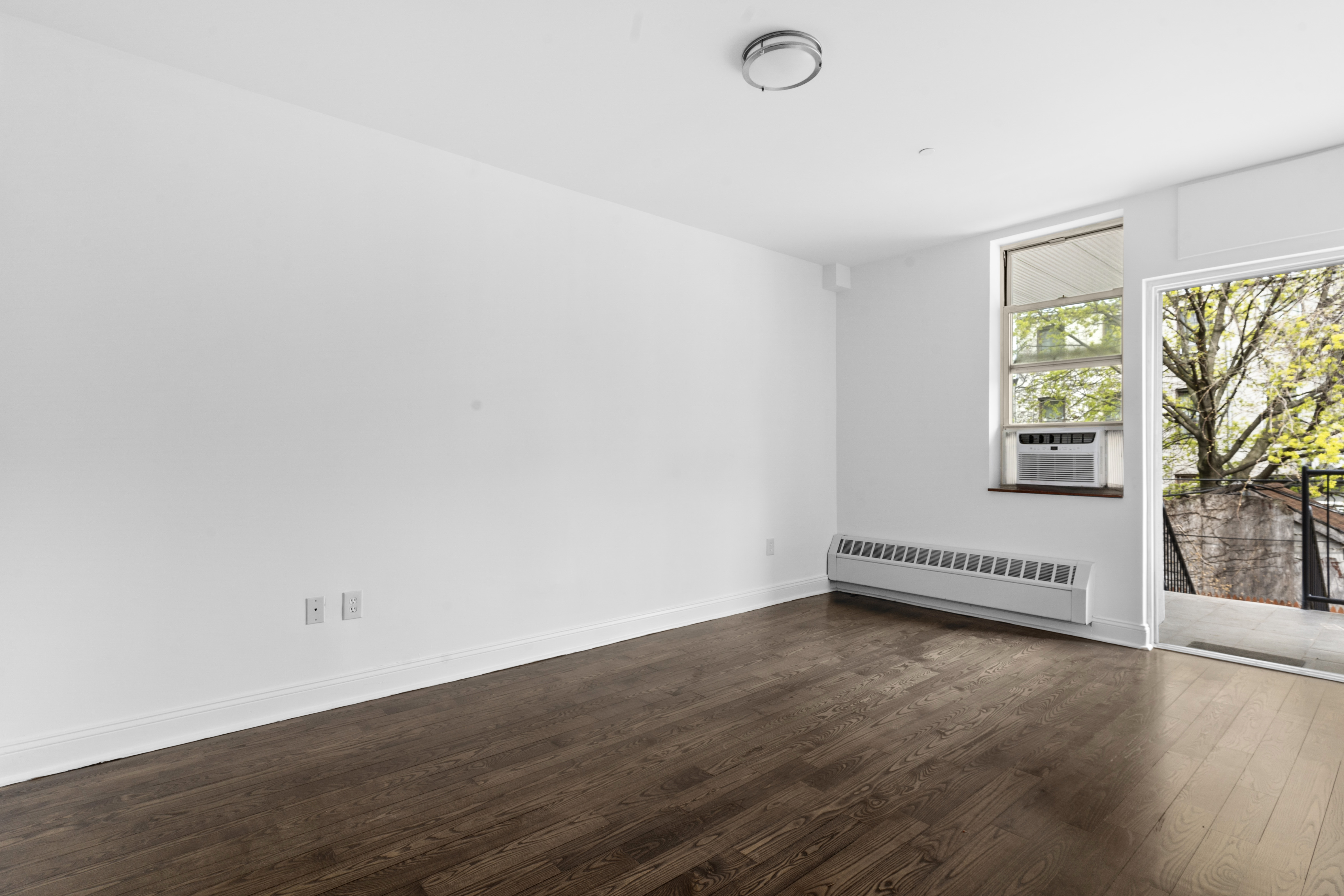 269 8th Street, Unit 2R Brooklyn, NY 11215 - Photo 7 of 14 an empty room with wooden floor and windows