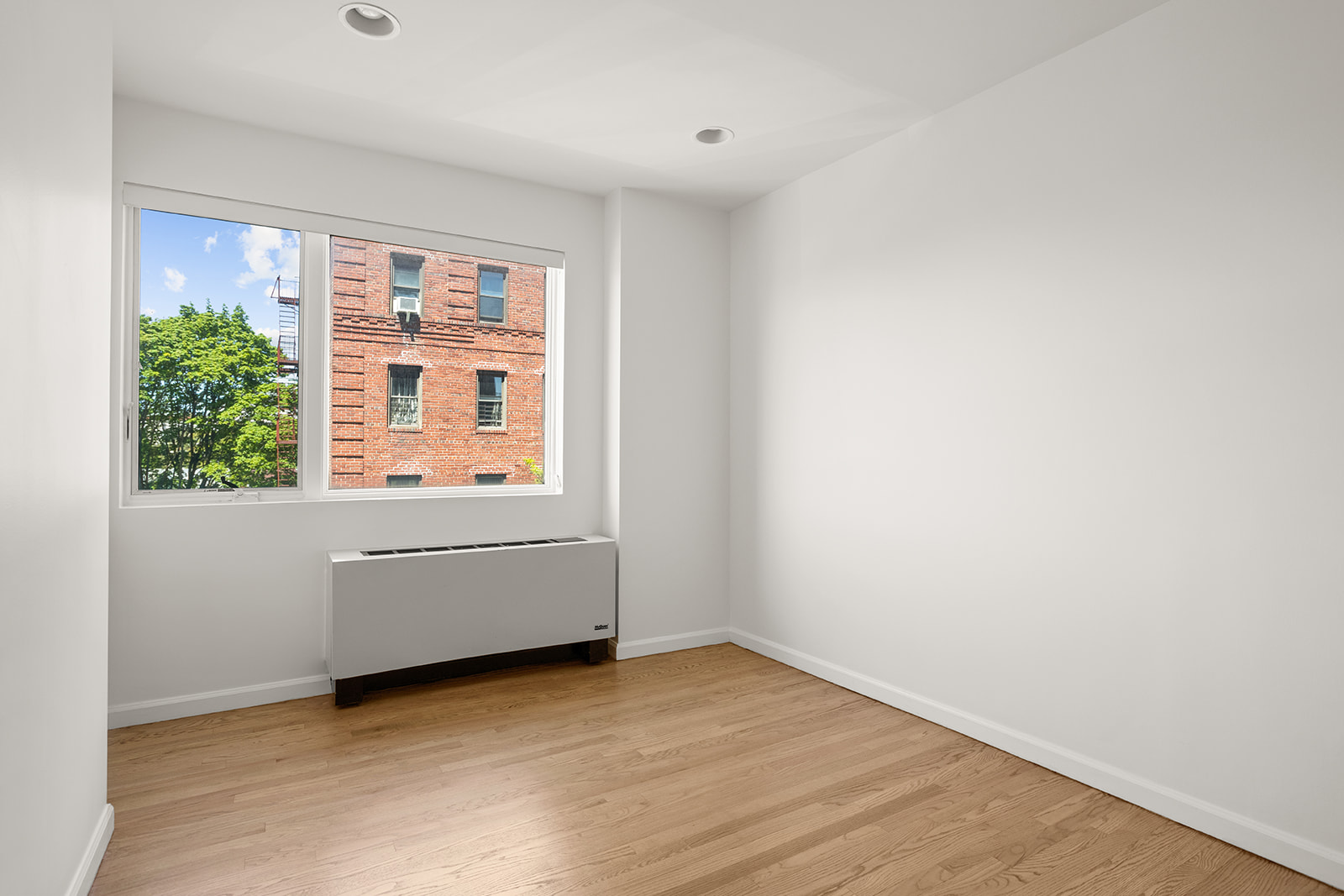 702 Ocean Parkway, Unit 5R Brooklyn, NY 11230 - Photo 10 of 13 an empty room with wooden floor and windows