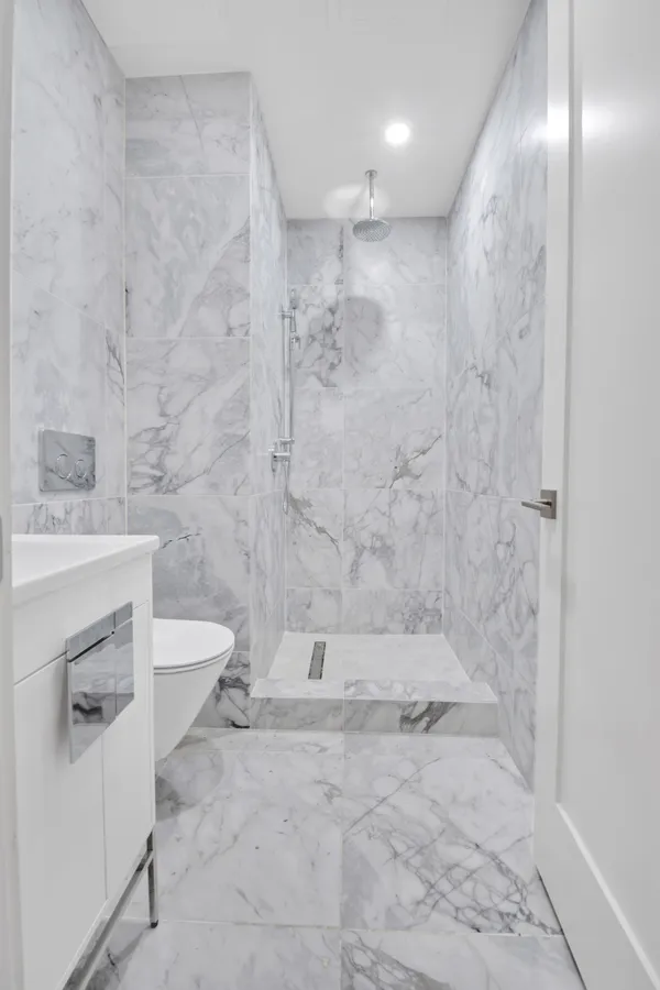 a bathroom with a sink a toilet and shower