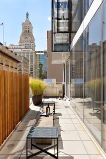a roof deck with couch and chairs