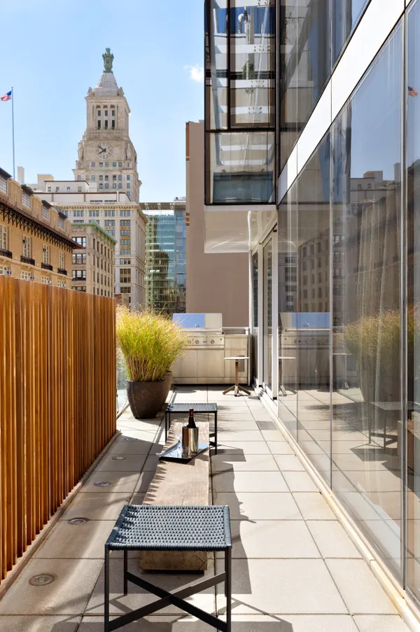 a roof deck with couch and chairs