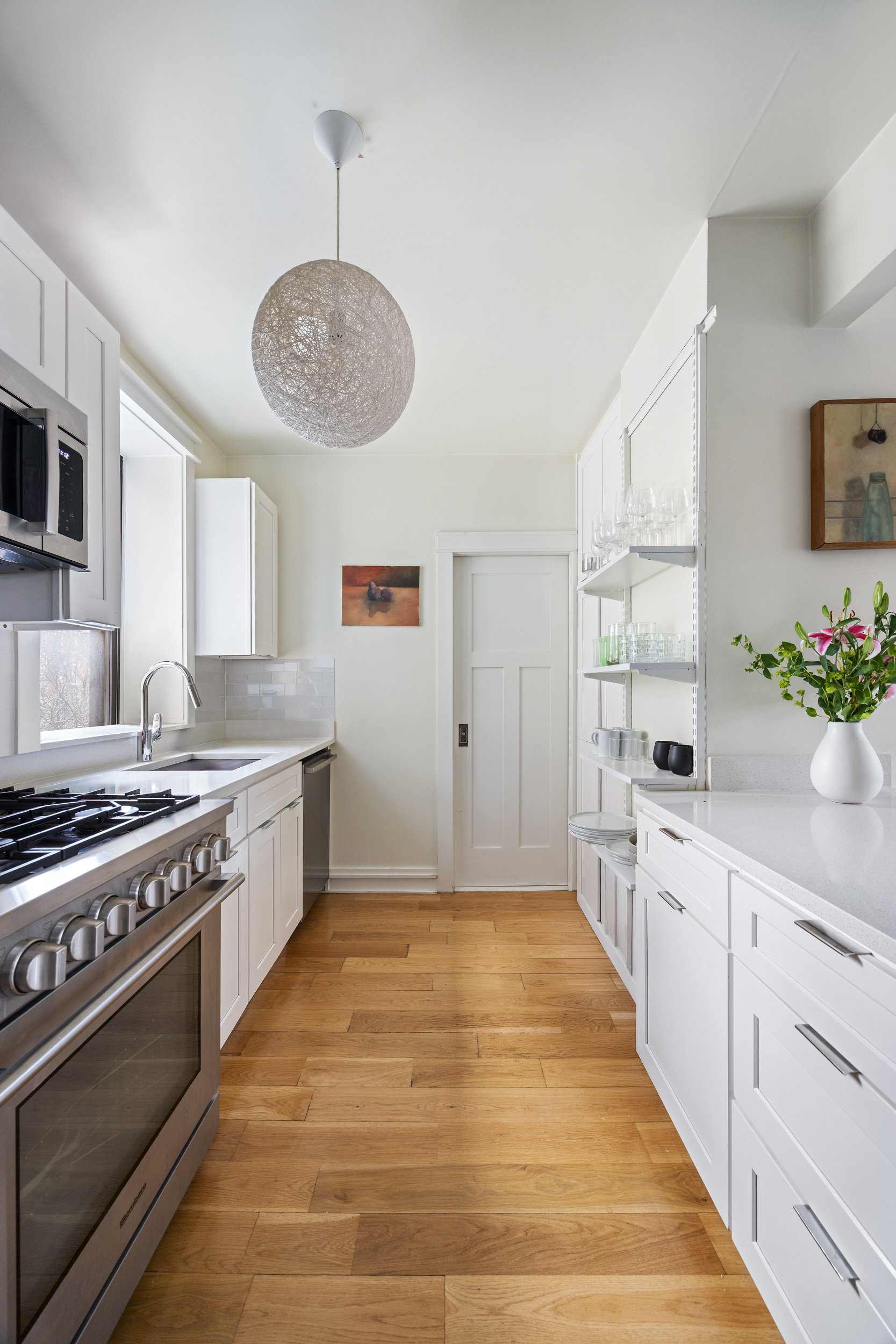 342 West 21st Street, Unit 4B Manhattan, NY 10011 - Photo 4 of 9 a kitchen with stainless steel appliances a stove a sink and white cabinets