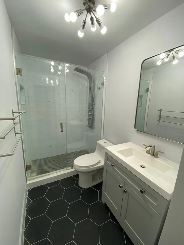 a bathroom with a shower a toilet and sink