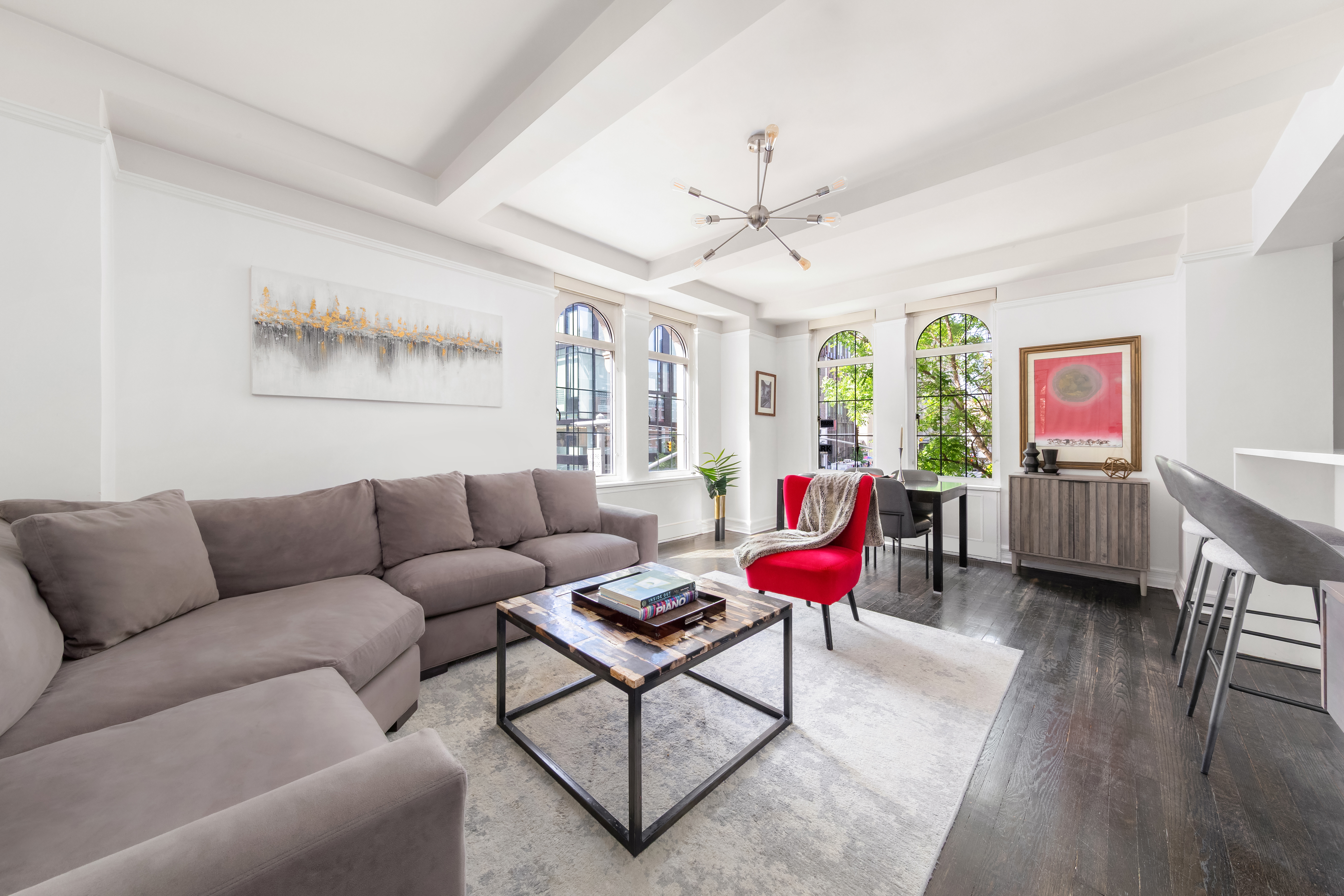 a living room with furniture kitchen view and a large window