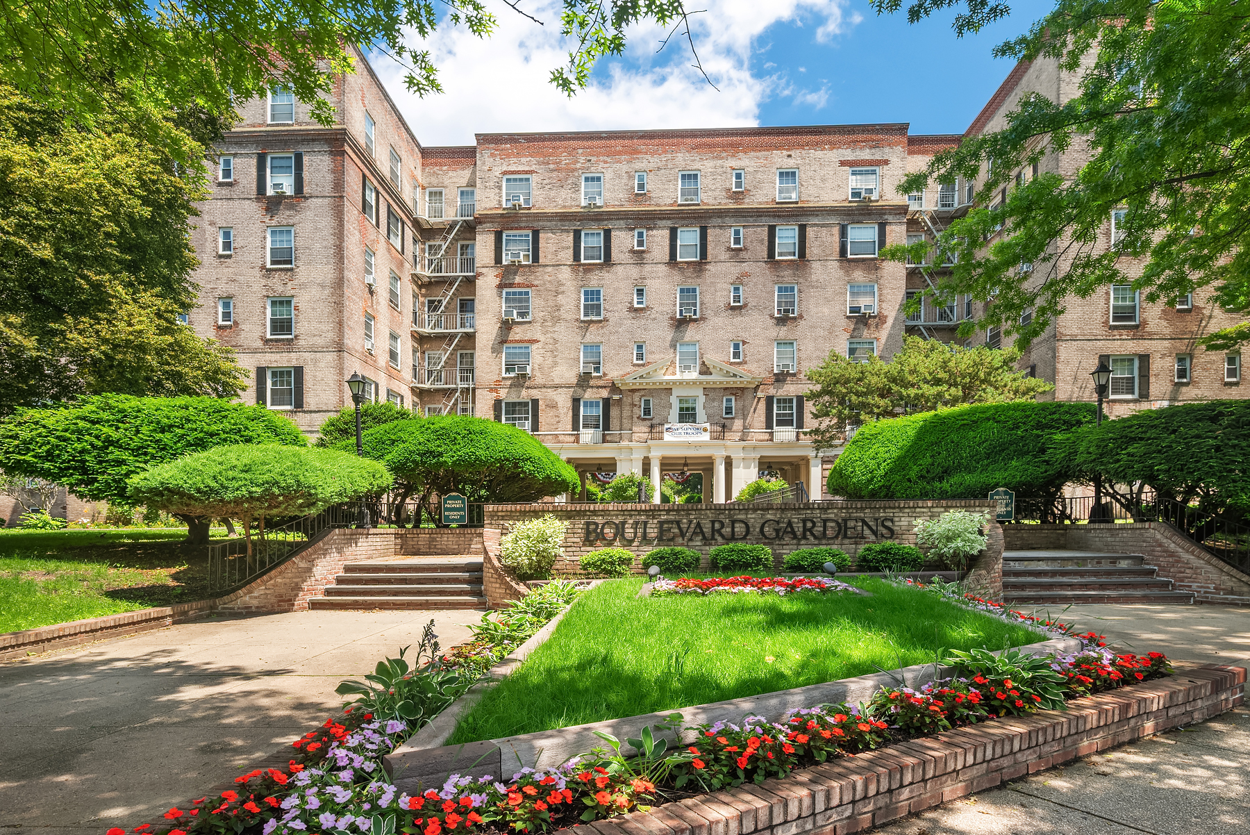 30-31 Hobart Street, Unit 3L Queens, NY 11377 - Photo 11 of 14 a front view of a building with garden and flowers