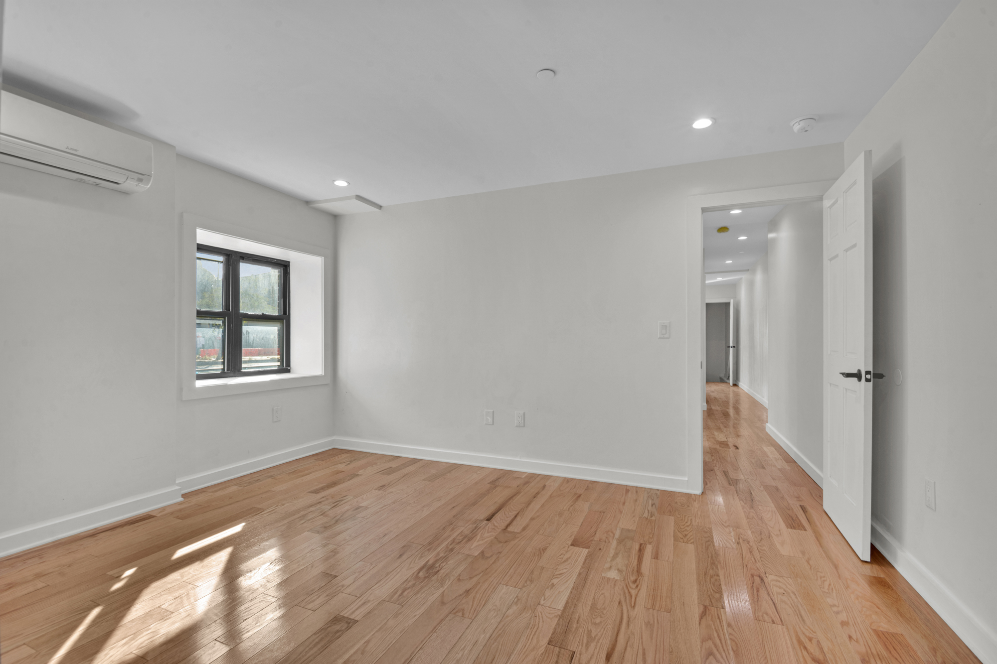 31 Roosevelt Place, Unit 1A Brooklyn, NY 11233 - Photo 6 of 14 a view of an empty room with wooden floor and a window