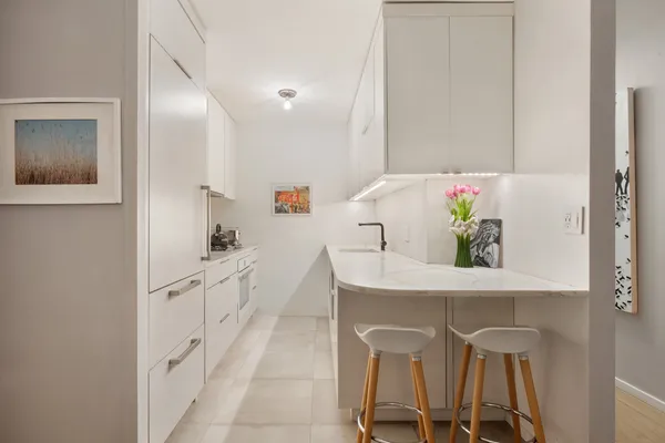 a kitchen with white cabinets and table
