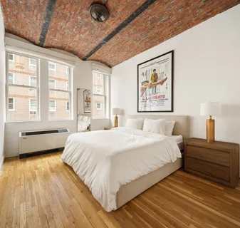 a spacious bedroom with a bed and a large window