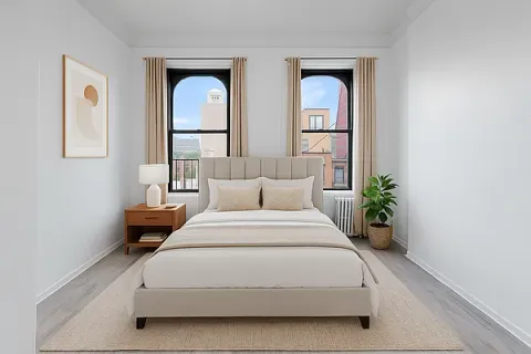 a spacious bedroom with a bed and a potted plant