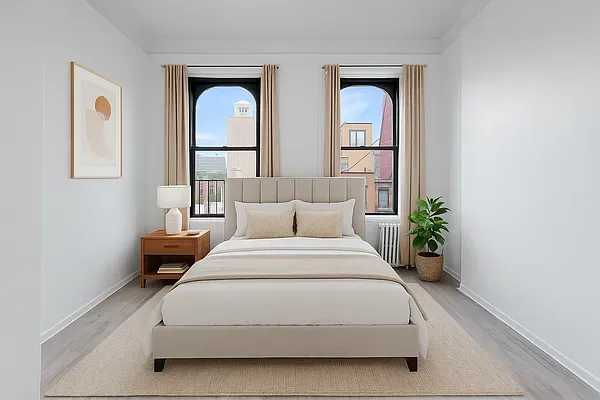 a spacious bedroom with a bed and a potted plant