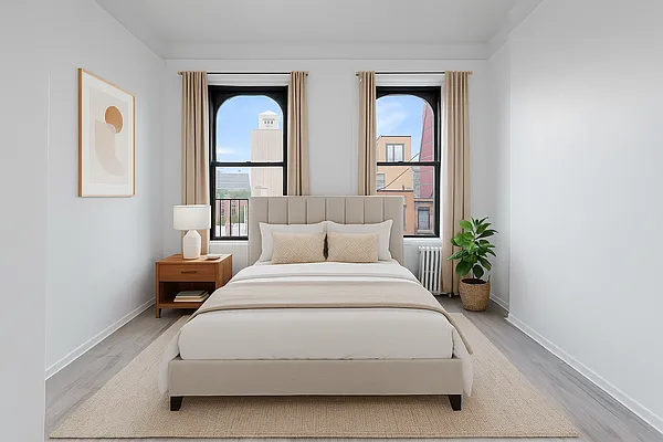 a spacious bedroom with a bed and a potted plant