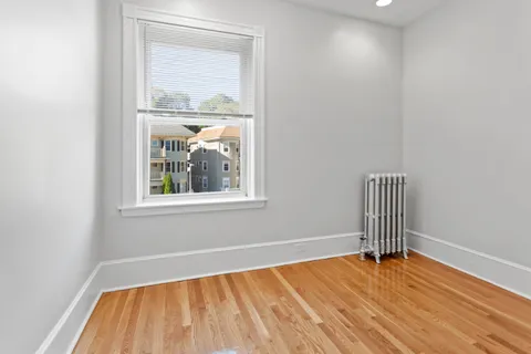 an empty room with wooden floor and a window