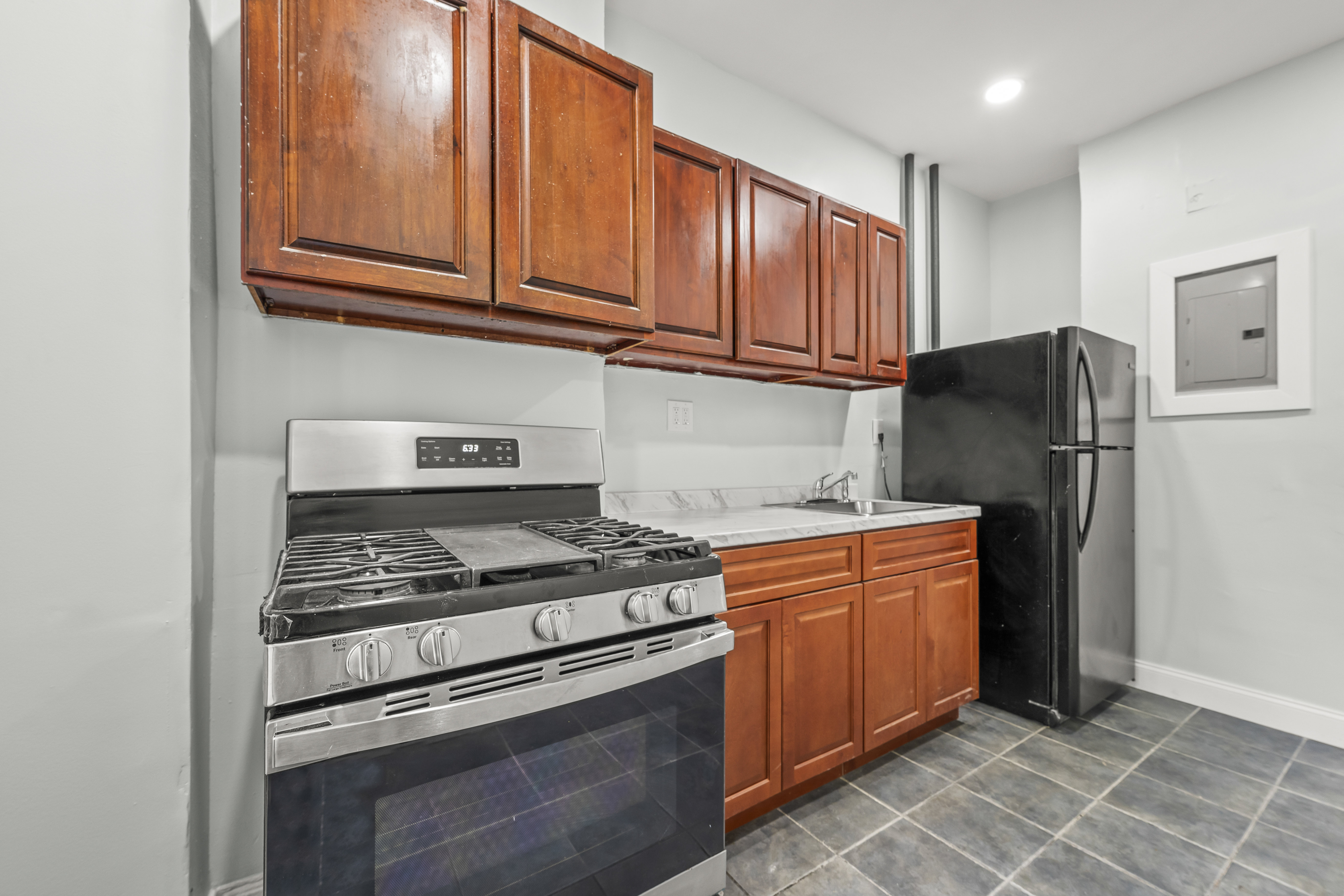 2023 Hughes Avenue Bronx, NY 10457 - Photo 5 of 63 a kitchen with stainless steel appliances granite countertop a refrigerator stove and sink