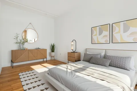 a bedroom with bed and wooden floor