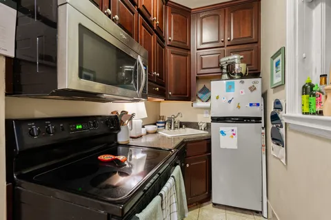 a kitchen with stainless steel appliances a stove a microwave a sink and cabinets