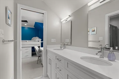 a bathroom with a granite countertop sink and a large mirror