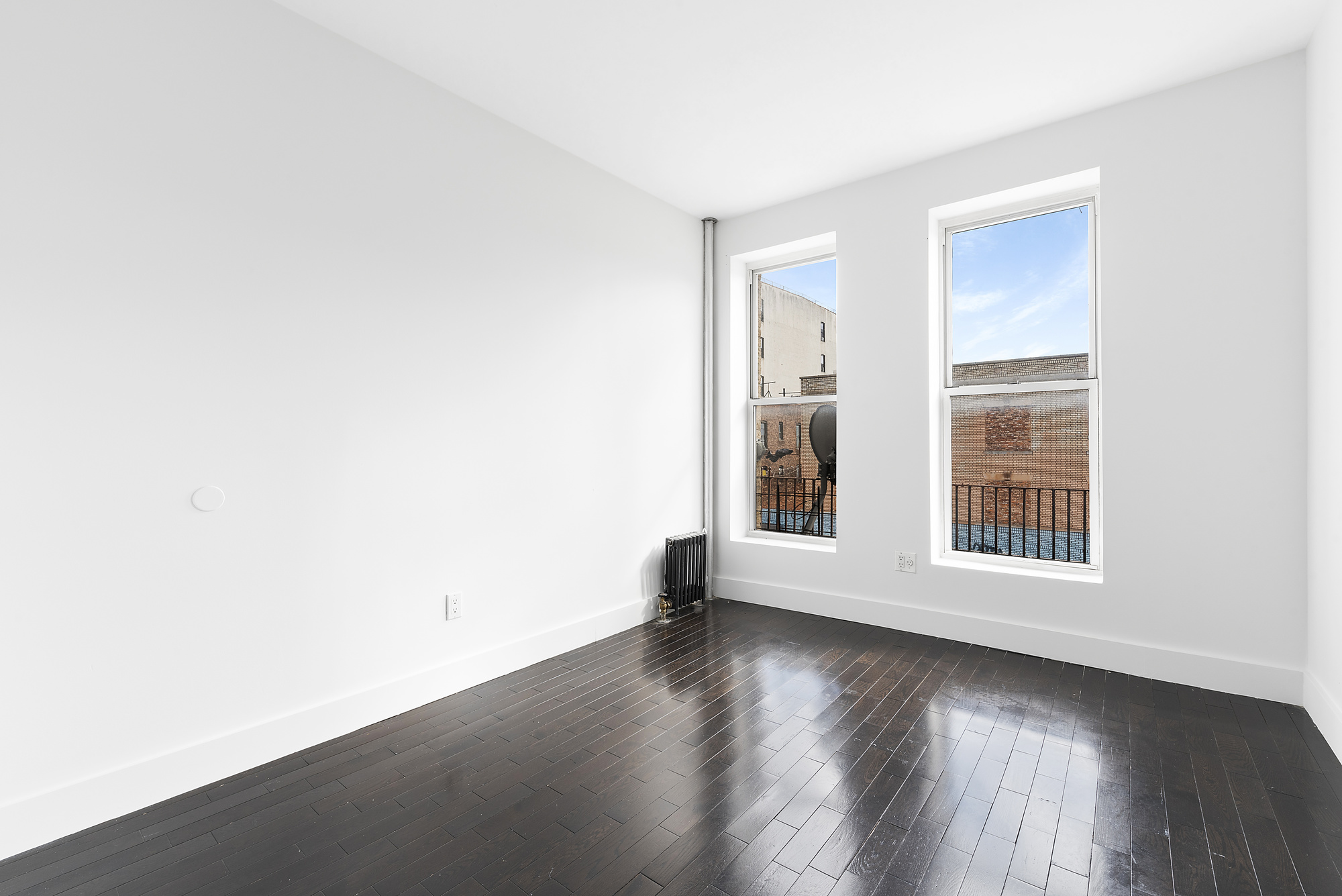701 Saint Marks Avenue, Unit 3B Brooklyn, NY 11216 - Photo 4 of 7 an empty room with wooden floor and windows