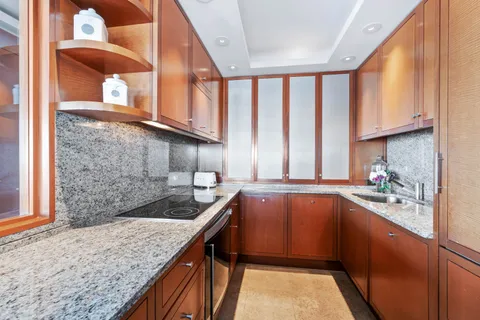 a kitchen with stainless steel appliances granite countertop a sink window and cabinets