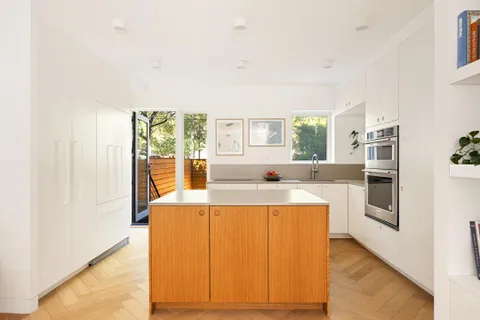 a large white kitchen with a large window