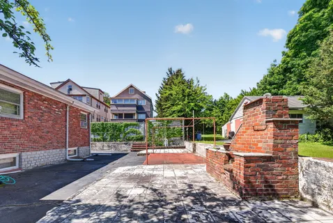 a view of a yard with brick wall and a fire pit