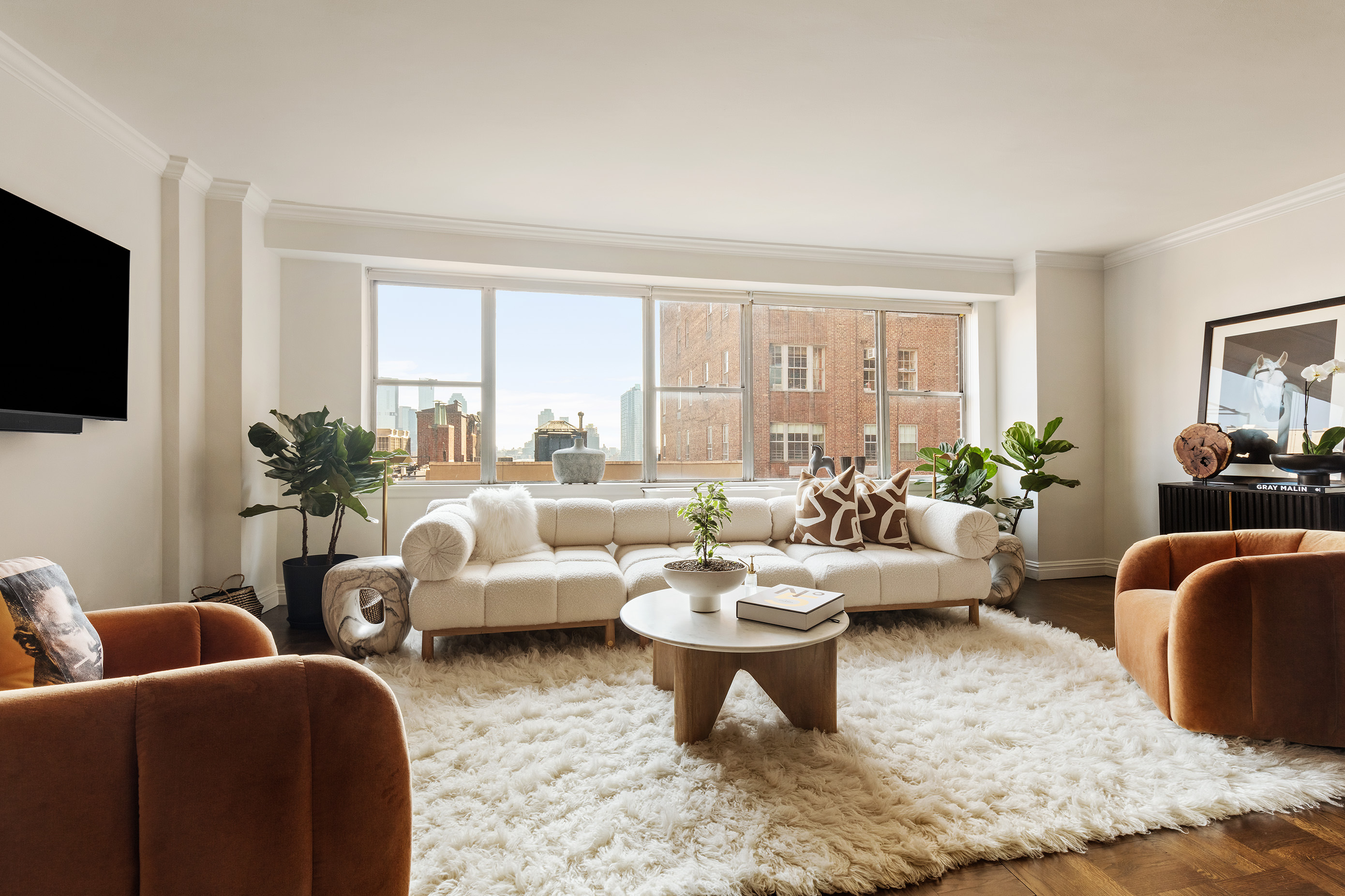 12 Beekman Place, Unit 7/8B Manhattan, NY 10022 - Photo 3 of 17 a living room with furniture a flat screen tv and a large window