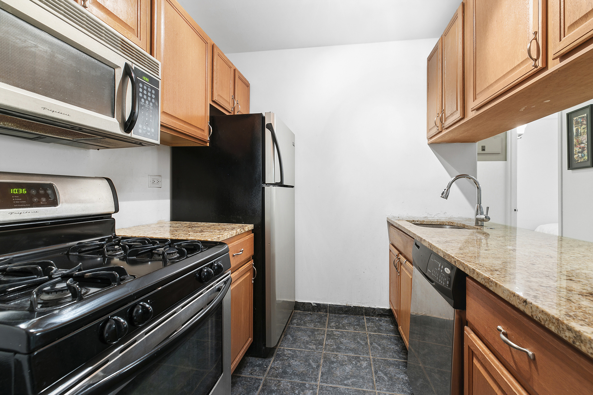377 Rector Place, Unit 1D Manhattan, NY 10280 - Photo 3 of 6 a kitchen with stainless steel appliances granite countertop a stove and a refrigerator