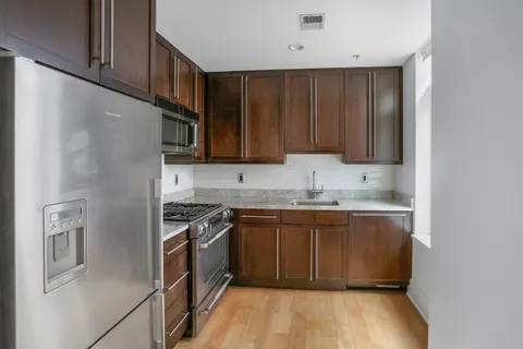 a kitchen with stainless steel appliances granite countertop a stove a sink and a refrigerator