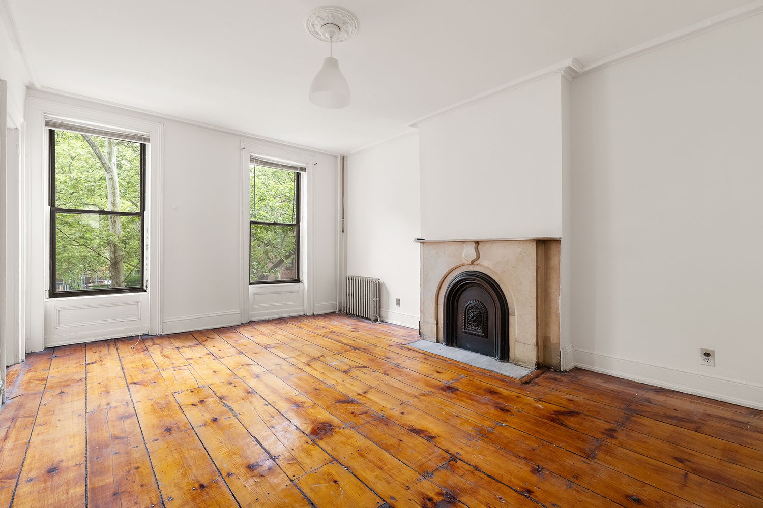 a view of a livingroom with a fireplace wooden floor and window