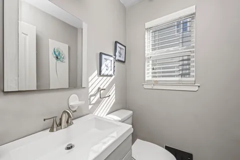 a bathroom with a sink a toilet and a mirror