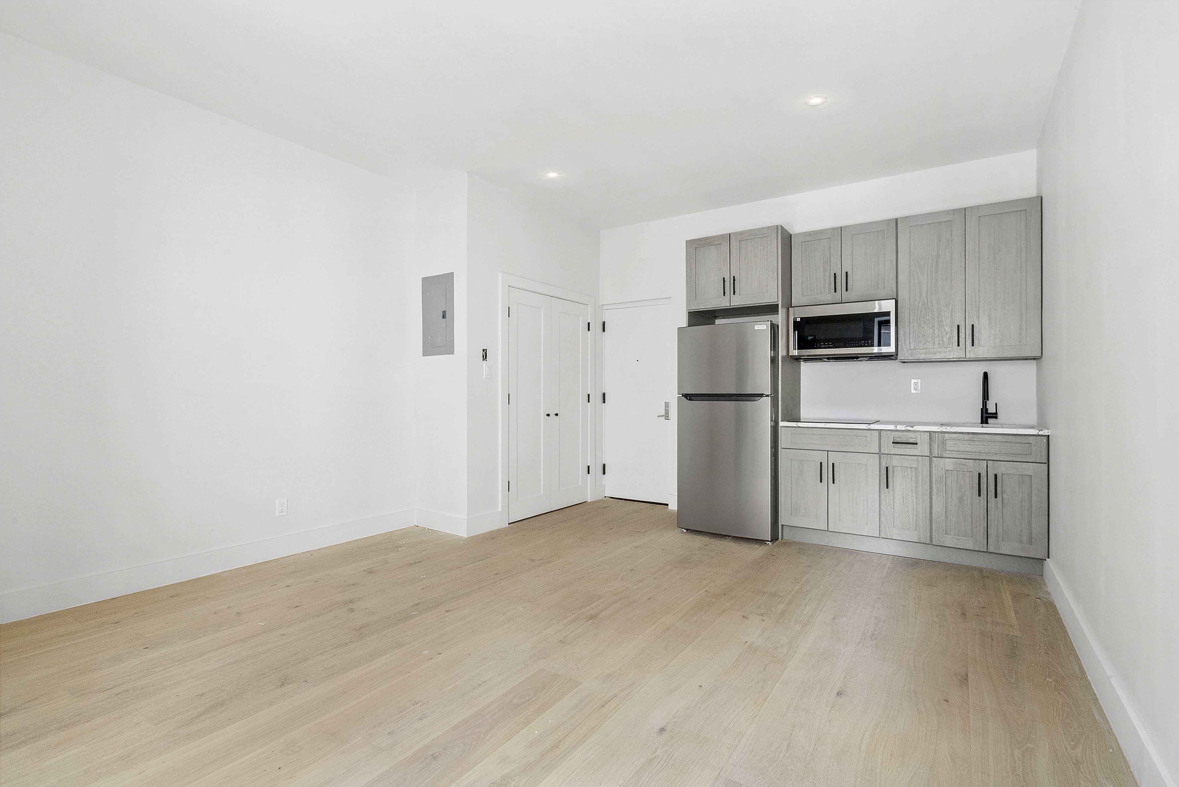 20 East 66th Street, Unit 5B Manhattan, NY 10065 - Photo 3 of 9 a kitchen with white cabinets and stainless steel appliances