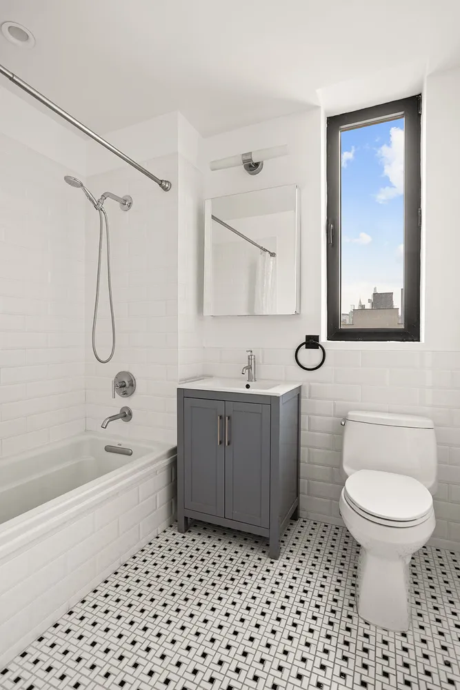 a bathroom with a bathtub shower sink mirror and toilet