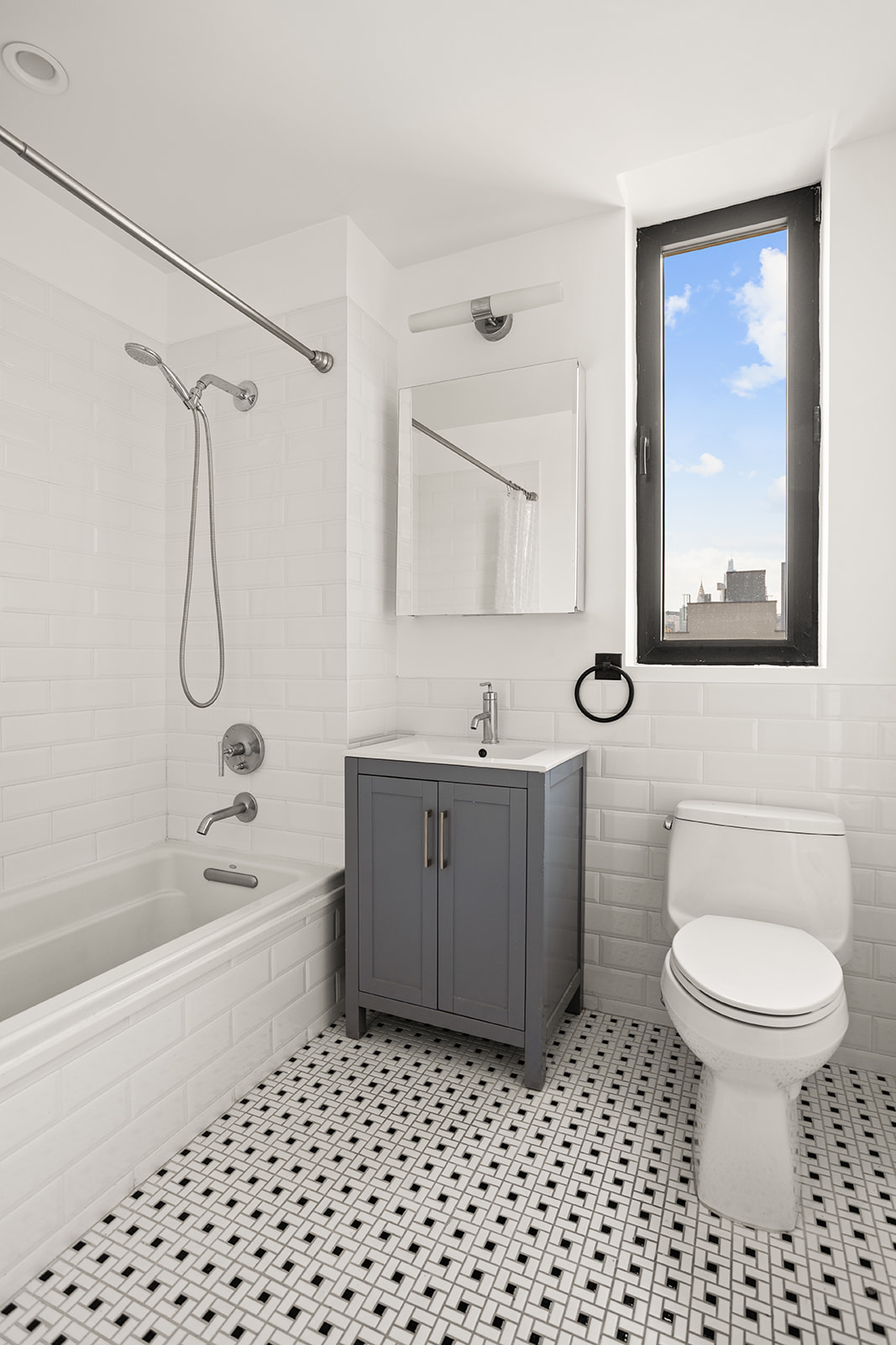 21-10 44th Drive, Unit PHA Queens, NY 11101 - Photo 11 of 18 a bathroom with a bathtub shower sink mirror and toilet