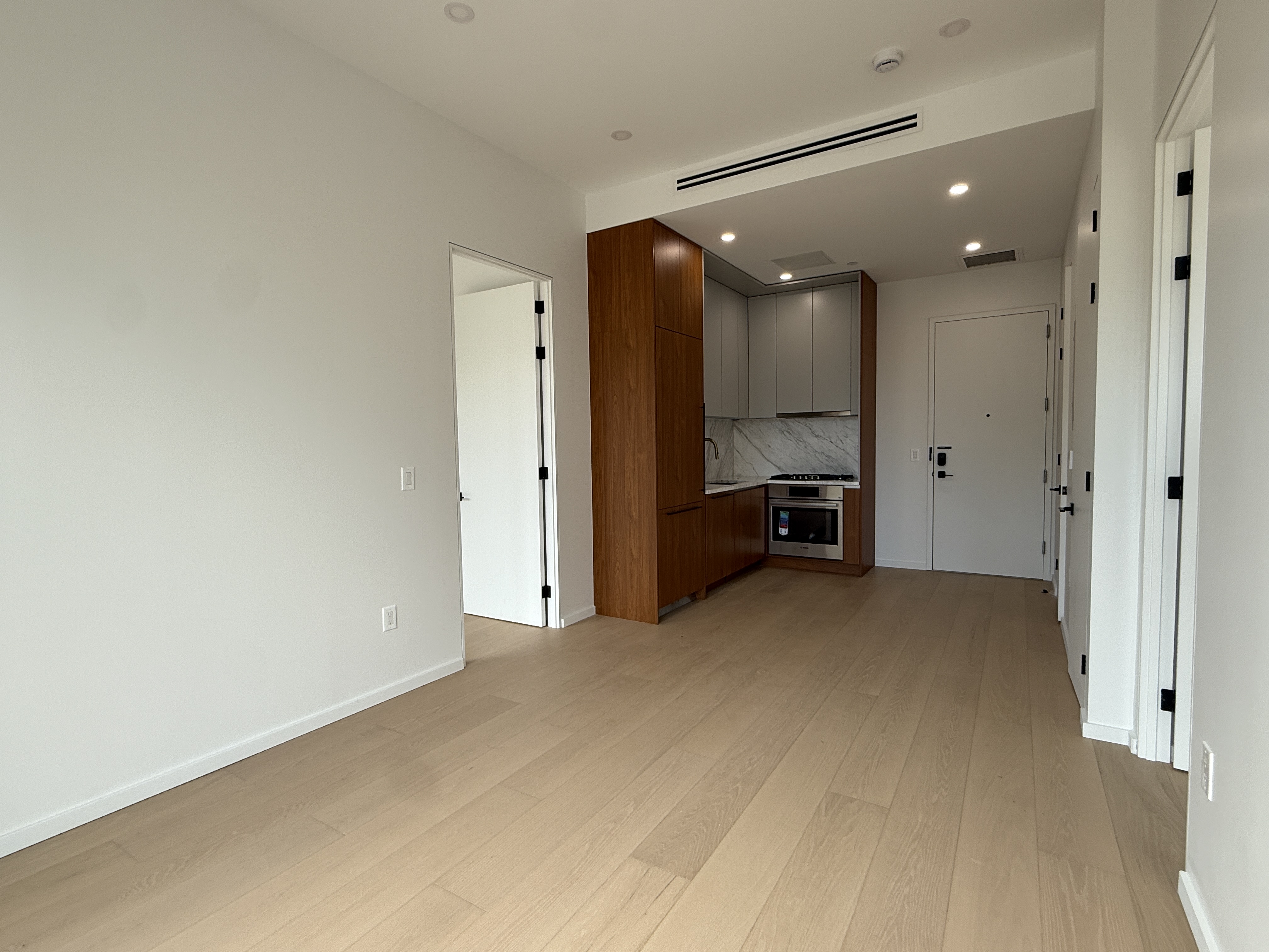 31-16 21st Street, Unit 3E Queens, NY 11106 - Photo 2 of 17 a view of empty room with kitchen