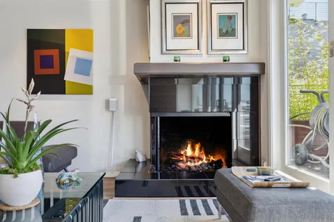 a kitchen with stainless steel appliances granite countertop a stove a sink a refrigerator a microwave oven with white cabinets and wooden floor