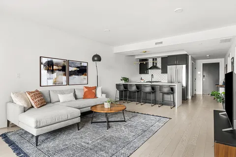 a living room with furniture and view of kitchen