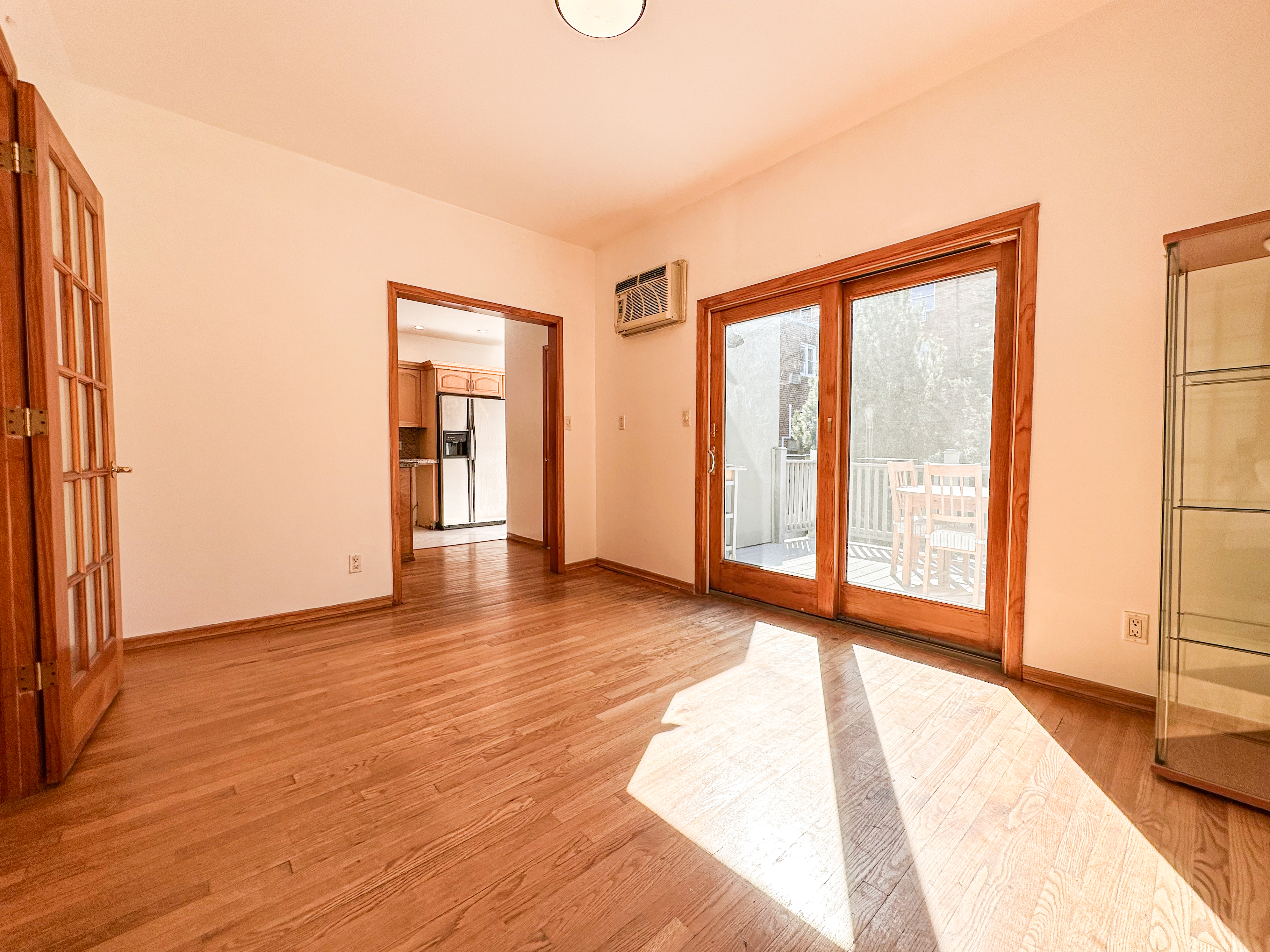 66-42 Clinton Avenue, Unit 2 Queens, NY 11378 - Photo 2 of 14 a view of an empty room with wooden floor and a window
