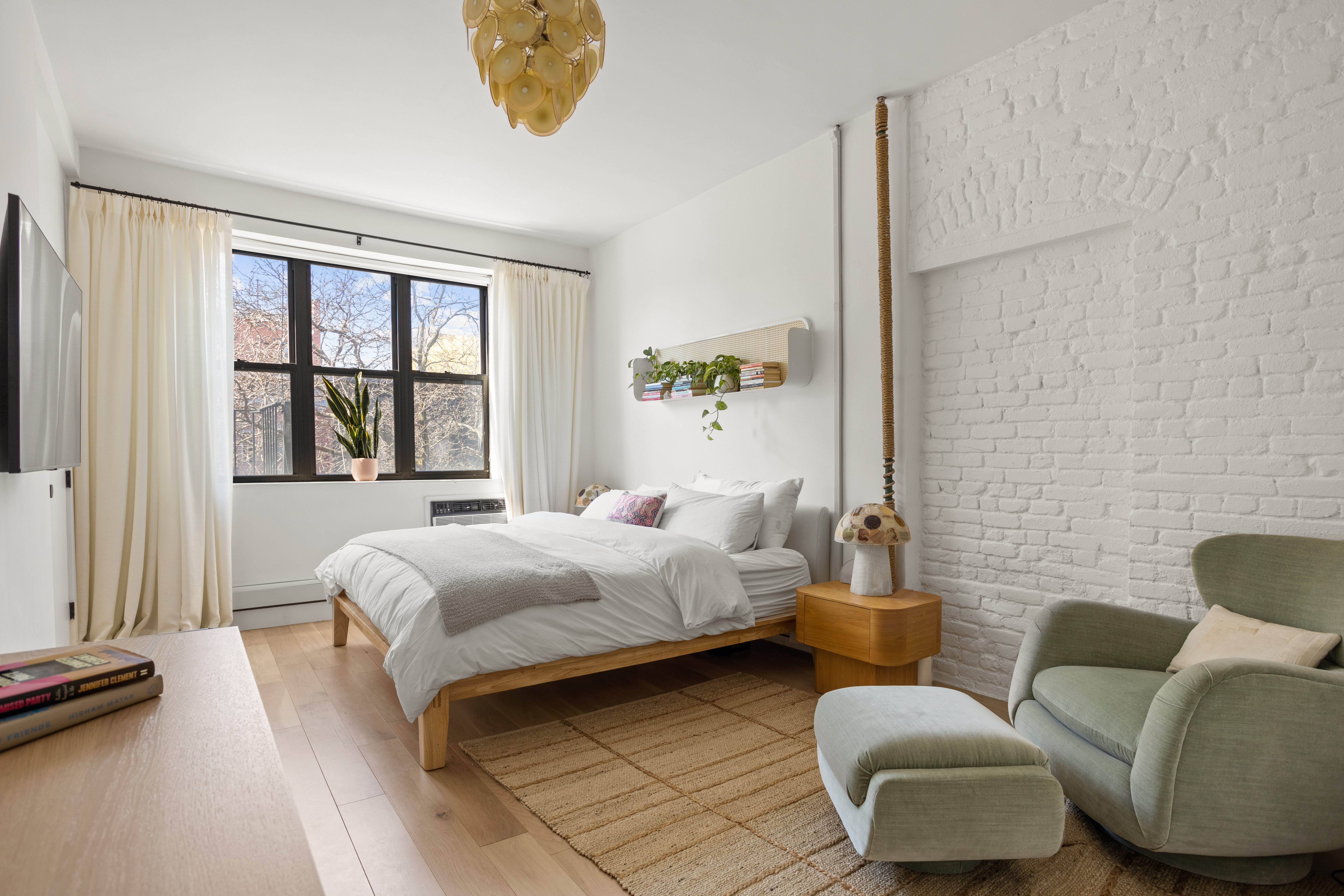 537 East 6th Street, Unit 5 Manhattan, NY 10009 - Photo 2 of 12 a bedroom with a bed couch and a window