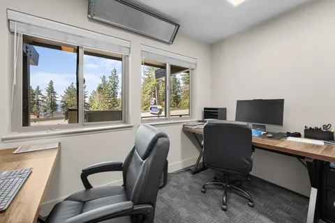a view of a workspace with furniture and a window