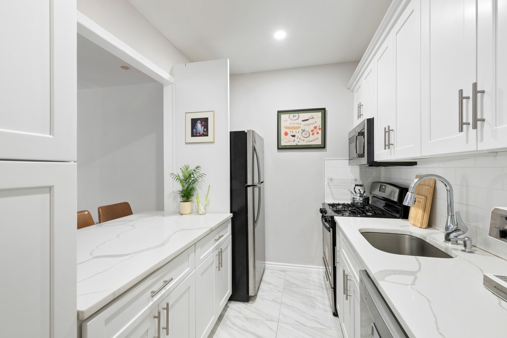 120 Manhattan Avenue, Unit 2A Manhattan, NY 10025 - Photo 2 of 10 a kitchen with stainless steel appliances a sink a stove a refrigerator a counter top space and cabinets